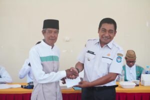 Camat Sungai Kakap Junaidi saat menyerahkan bonus kepada salah satu pemenang dari kafilah Sungai Kakap.
